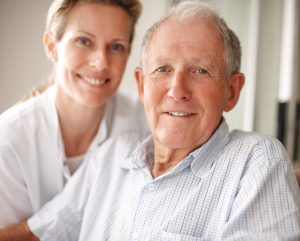 photo of elderly man and young assistant