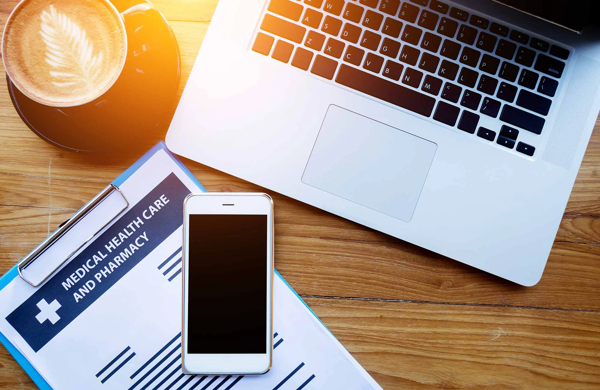 photo of a smartphone and laptop open on a desk